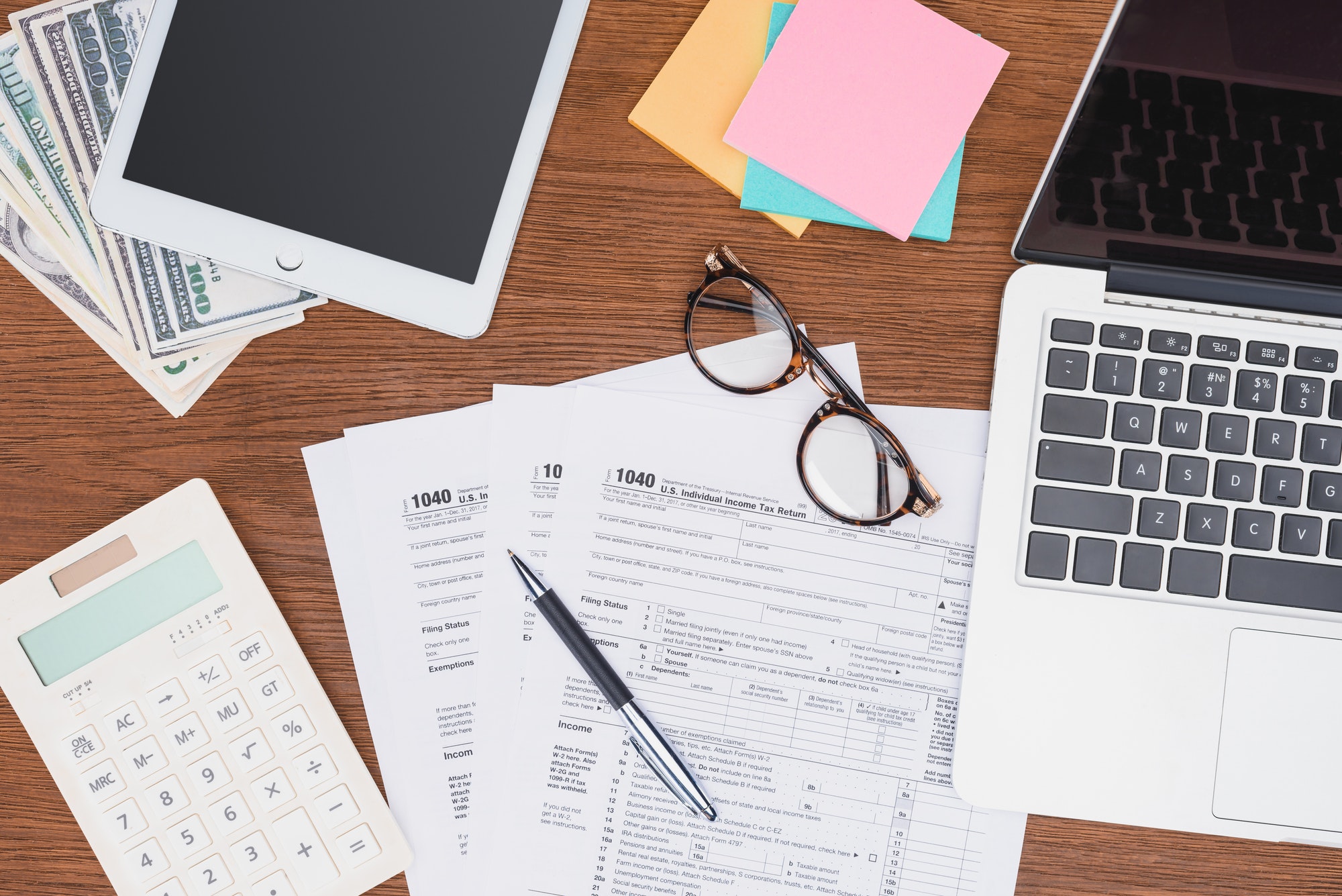 top-view-of-tax-forms-digital-devices-and-stationery-on-desk.jpg